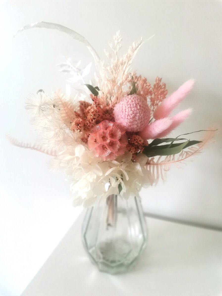 dried-pink-flowers-sit-in-a-faceted-glass-vase