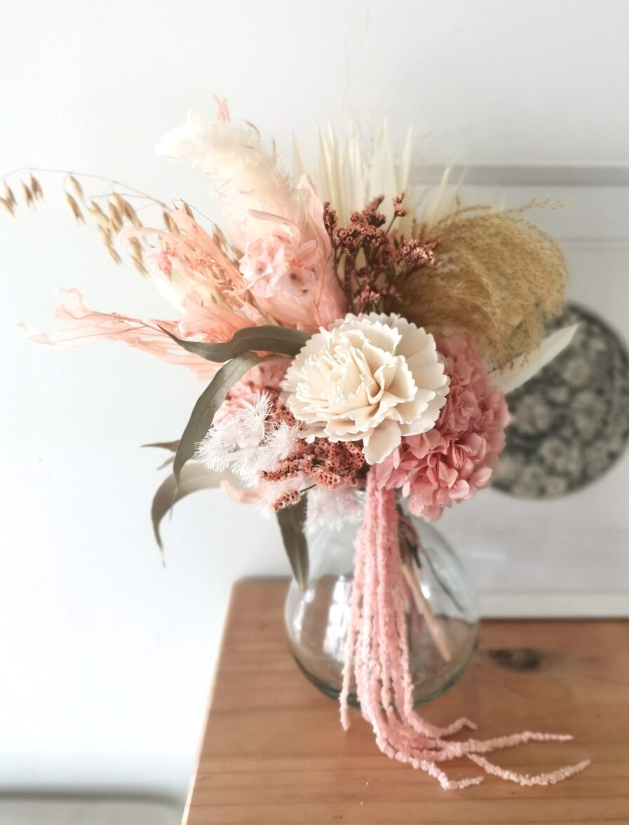 pink-and-white-dried-flowers-that-drape-down-in-a-glass-bubble-vase