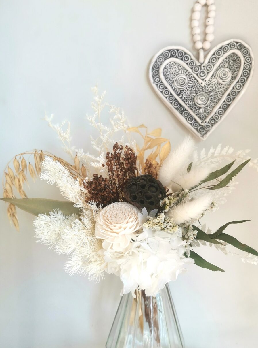 white-and-brown-dried-flowers-have-been-arranged-in-a-faceted-glass-vase